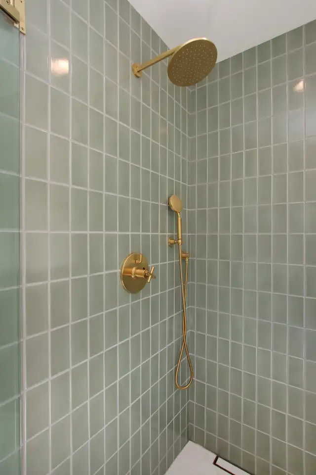 Santa Cruz Mountains primary bath shower with sage green Fireclay tile and a brushed brass rain head